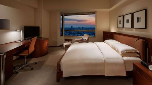 a hotel room with a bed and a desk and a window at Grand Hyatt Tokyo in Tokyo