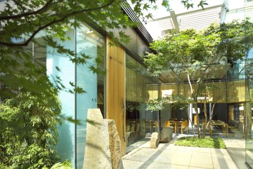 a glass facade of a building with trees at Grand Hyatt Tokyo in Tokyo