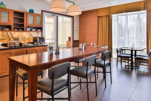 a dining room with a large wooden table and chairs at Hyatt Place Chesapeake in Chesapeake