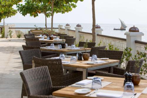 an outdoor restaurant with tables and chairs and the ocean at Park Hyatt Zanzibar in Zanzibar City