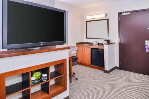 a hotel room with a large flat screen tv at Hyatt Place Chesapeake in Chesapeake