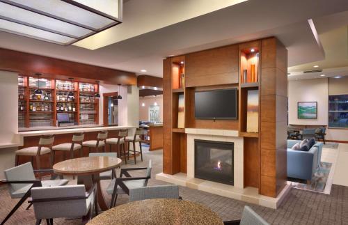 a hotel lobby with a fireplace and tables and chairs at Hyatt House Salt Lake City/Sandy in Sandy