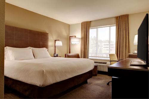 a hotel room with a bed and a desk and a window at Hyatt House Seattle Bellevue in Bellevue