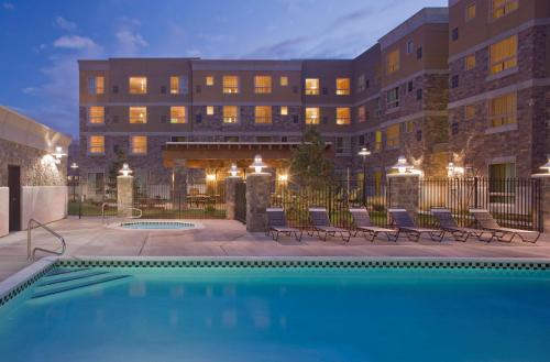 a hotel with a swimming pool in front of a building at Hyatt House Salt Lake City/Sandy in Sandy