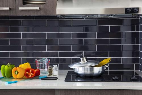 a kitchen counter with vegetables and a pot on a stove at Hyatt House New York/Chelsea in New York