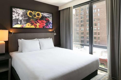 a bedroom with a large bed and a large window at Hyatt House New York/Chelsea in New York