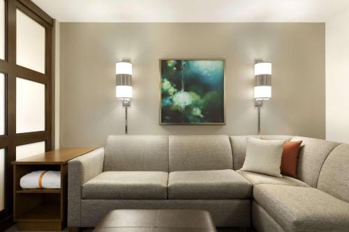 a living room with a couch and a table at Hyatt Place Portland Airport/Cascade Station in Portland