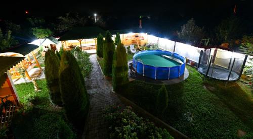 a backyard at night with a swimming pool at Pensiunea Mama Lia in Haţeg