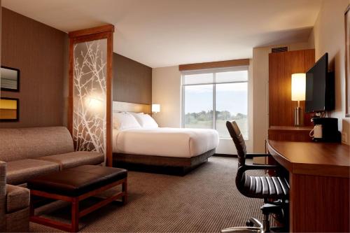 a hotel room with a bed and a desk at Hyatt Place Madison/Verona in Verona