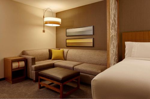 a hotel room with a couch and a bed at Hyatt Place Madison/Verona in Verona