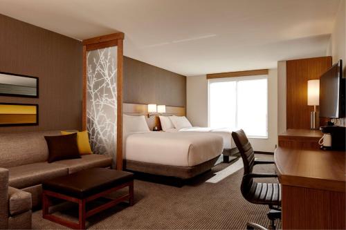a hotel room with a bed and a couch at Hyatt Place Madison/Verona in Verona
