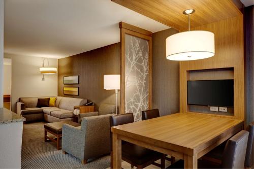 a living room with a dining room table and a couch at Hyatt Place Madison/Verona in Verona