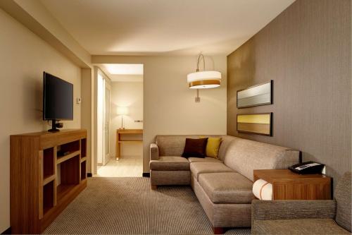 a living room with a couch and a tv at Hyatt Place Madison/Verona in Verona