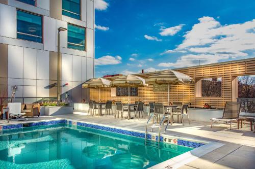 a swimming pool with tables and chairs next to a building at Hyatt Place Washington D.C./National Mall in Washington