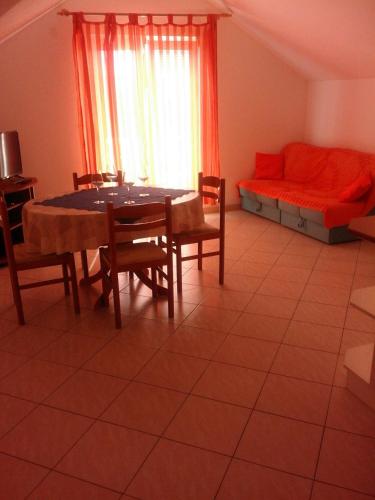 a living room with a table and chairs and a bed at Apartments Jerica in Bol