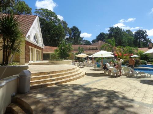 a group of people sitting under umbrellas near a pool at Green Park Departamentos Exclusivos in Punta del Este
