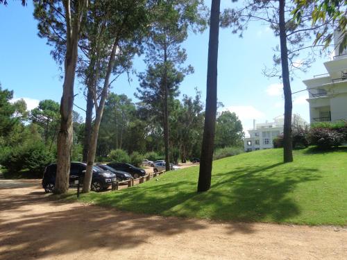 a group of cars parked in a park with trees at Green Park Departamentos Exclusivos in Punta del Este