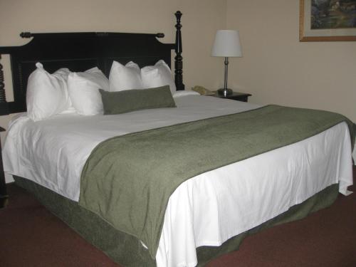 a bedroom with a large bed with white sheets and pillows at Glynmill Inn in Corner Brook