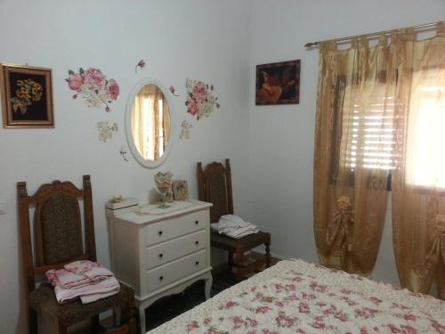 - une chambre avec un lit, une commode et un miroir dans l'établissement Casa di Lory a Bruca, à Scicli