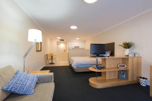 un soggiorno con letto e divano di Grande Esplanade Studio a Sydney