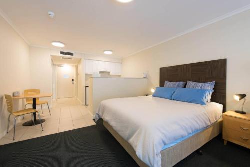 a bedroom with a large white bed and a table at Grande Esplanade Studio - New bathroom in Sydney
