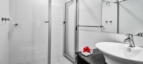 Tanoa Skylodge Hotel في نادي: حمام أبيض مع دش ومغسلة