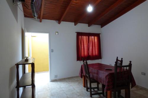 ein Esszimmer mit einem Tisch und einem roten Vorhang in der Unterkunft Departamento Centrico Laprida in Cordoba