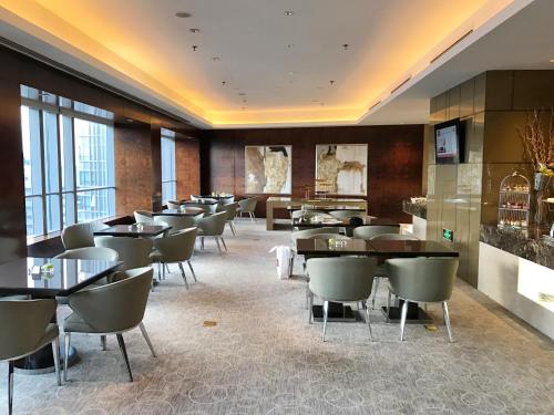 a restaurant with tables and chairs in a room at Grand Millennium Beijing in Beijing