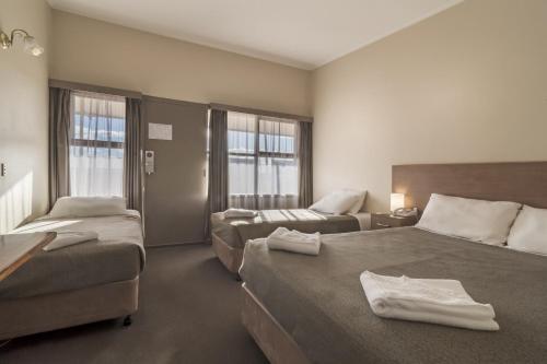 Un pat sau paturi într-o cameră la Argosy Motor Inn