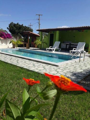 a house with a swimming pool with chairs and flowers at Pousada Vale Encantado in Serra de São Bento