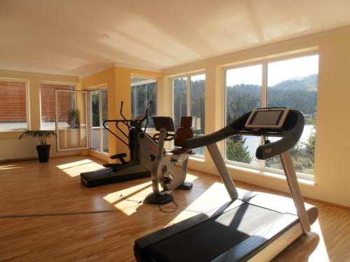 a gym with three exercise bikes in a room with windows at Sundance Mountain Resort in Turracher Hohe