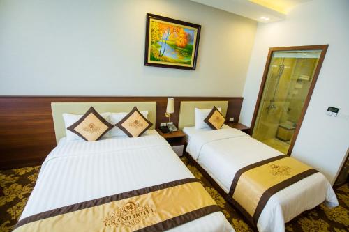 a hotel room with two beds in a room at Grand Hotel in Hòa Bình
