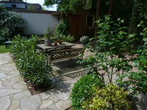 a wooden bench sitting in a garden with plants at Hotel Villa im Steinbusch in Malente
