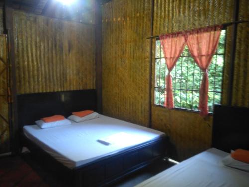 a small room with a bed and a window at Homestay Ngoc Sang in Vĩnh Long