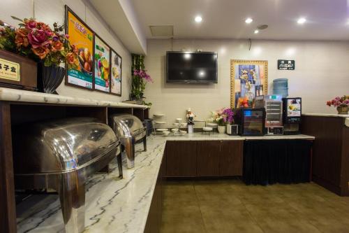 une salle d'attente avec un salon de coiffure avec une télévision au mur dans l'établissement Jinjiang Inn Beijing Hepingmen, à Pékin