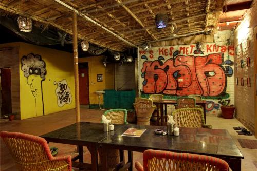 a room with a table and chairs and graffiti on the wall at Bedweiser Backpackers Hostel in Agra