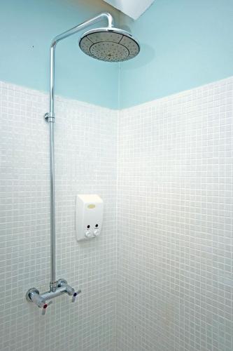 a shower in a bathroom with white tiles at Aqua Beads Samed in Ko Samed
