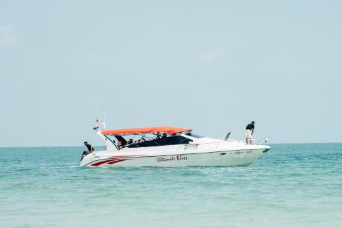 a boat in the water with two people on it at Buri Rasa Village Phangan in Thong Nai Pan Noi