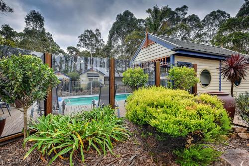 a house with a swimming pool in a yard at Waverley House Cottages in Lakes Entrance