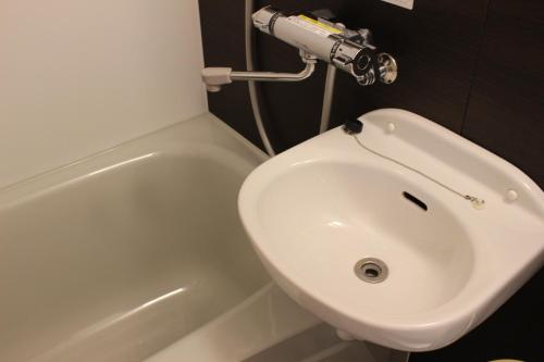 a white sink and a toilet in a bathroom at Nangoku Lodge Booya in Onna