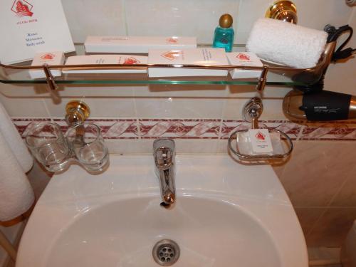a bathroom sink with a glass shelf above it at Гостиница ИЛЕК in Aktobe