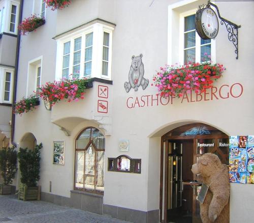 a building with a clock on the front of it at Hotel Grauer Bär in Bressanone