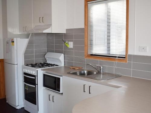 a kitchen with a sink and a stove top oven at Cohuna Waterfront Holiday Park in Cohuna