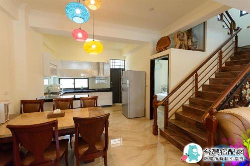 a kitchen and dining room with a table and a staircase at Sand Po Dang B&B II in Jian