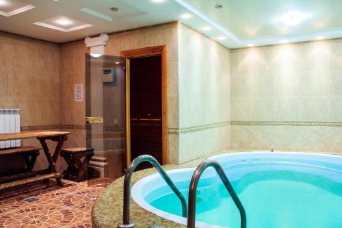 a jacuzzi tub in a room with a table at Parus Hotel in Lyskovo