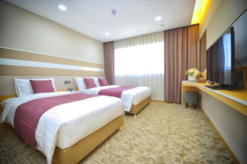 a hotel room with two beds and a television at The Recenz Dongdaemun Hotel in Seoul