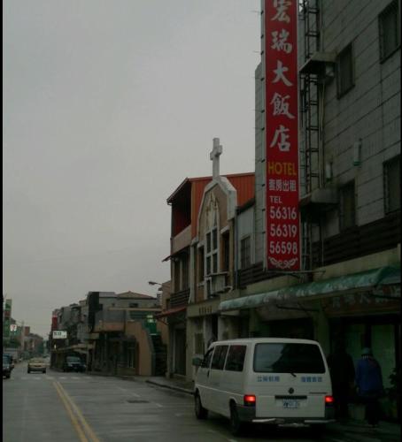 北竿鄉的住宿－宏瑞民宿，一辆白色面包车沿着建筑物旁边的街道行驶