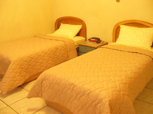 宏瑞民宿 في بيغان: غرفة فندقية بسريرين وطاولة