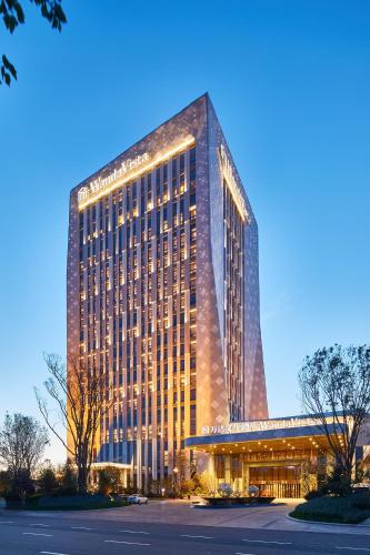 a tall building with lights on the side of it at Wanda Vista Harbin in Harbin
