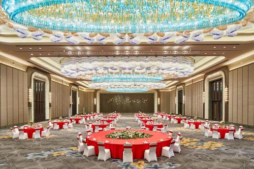 a large banquet hall with red and white tables at Wanda Vista Harbin in Harbin